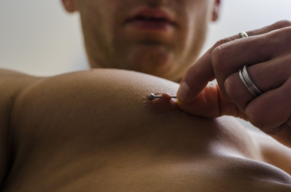 man playing with his nipple ring