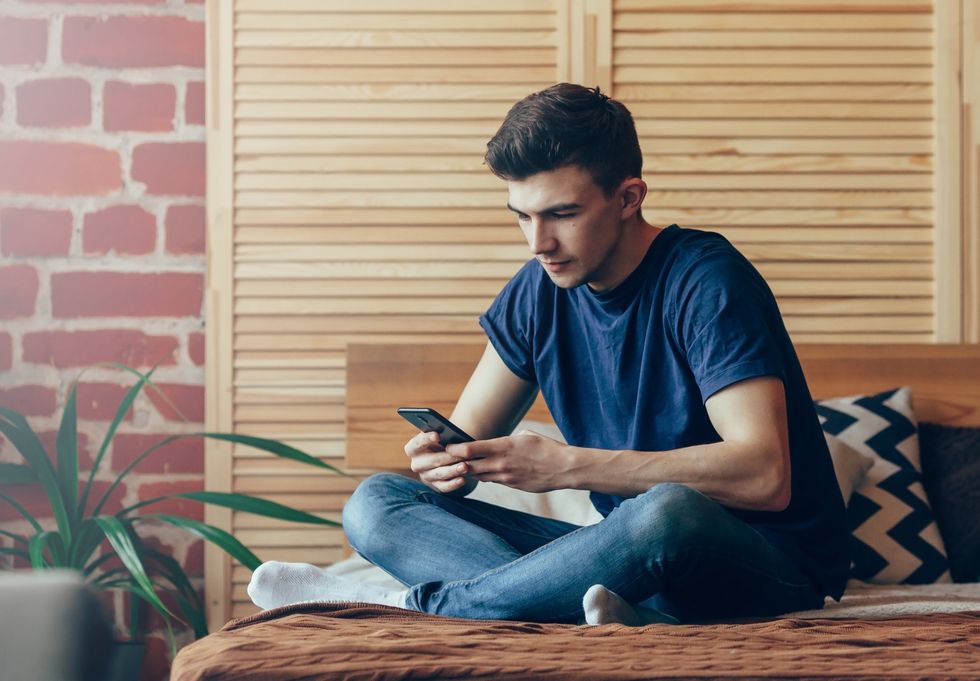 man sitting by himself on his phone