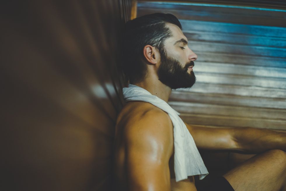 man sitting in a sauna with his eyes closed