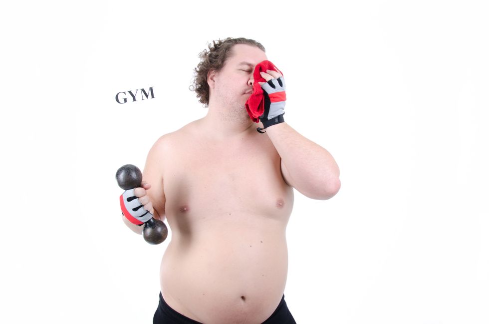 man smelling clothes and holding a weight