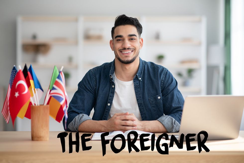 Man smiling next to country flags