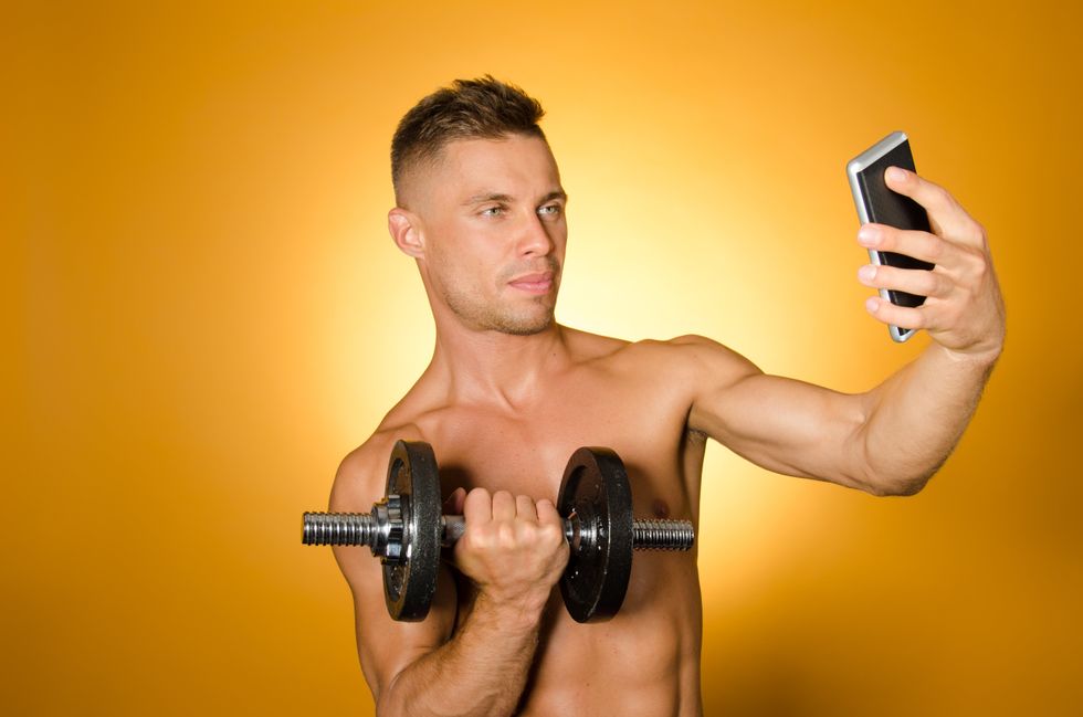 man taking a selfie with a dumbbell