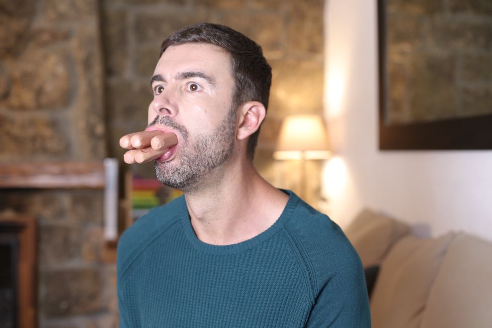 man with a lot of hot dogs in his mouth
