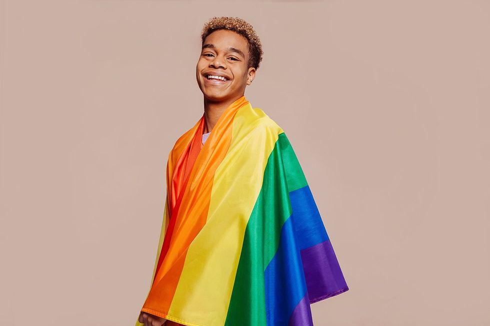 man wrapped in a pride rainbow flag