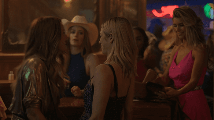 Margo Banks, Sophie O'Neil, Callie, Monae, and Taylor are at a table top at the bar, The Hunting Wives