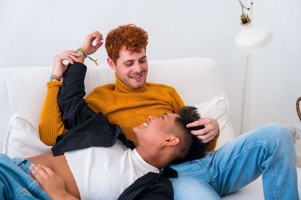 men cuddling on a couch