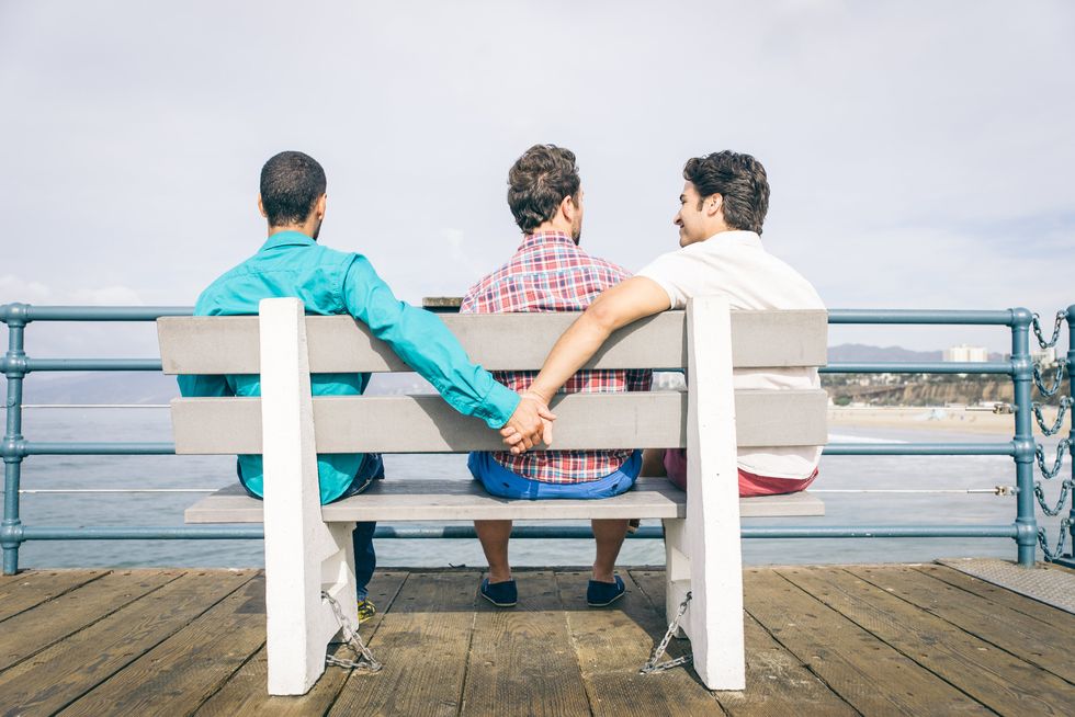 men holding hands behind someone's back