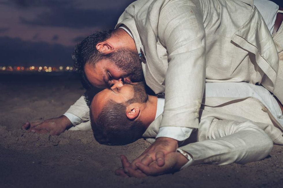 Men kiss on the beach