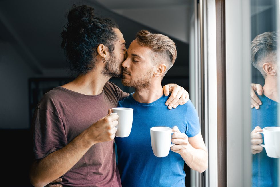 men kissing and drinking coffee