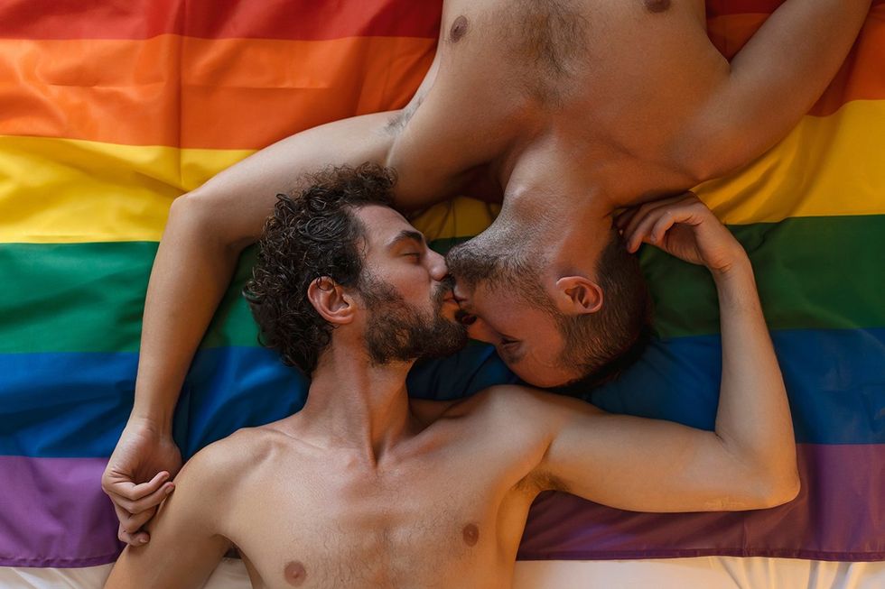 men kissing on a pride flag