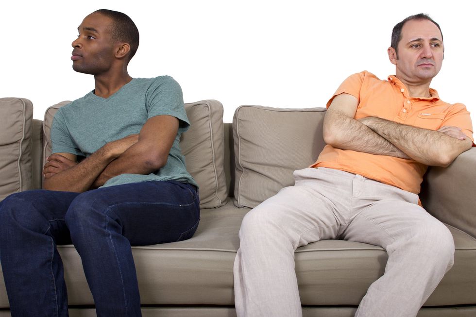 men sitting apart from each other on the couch
