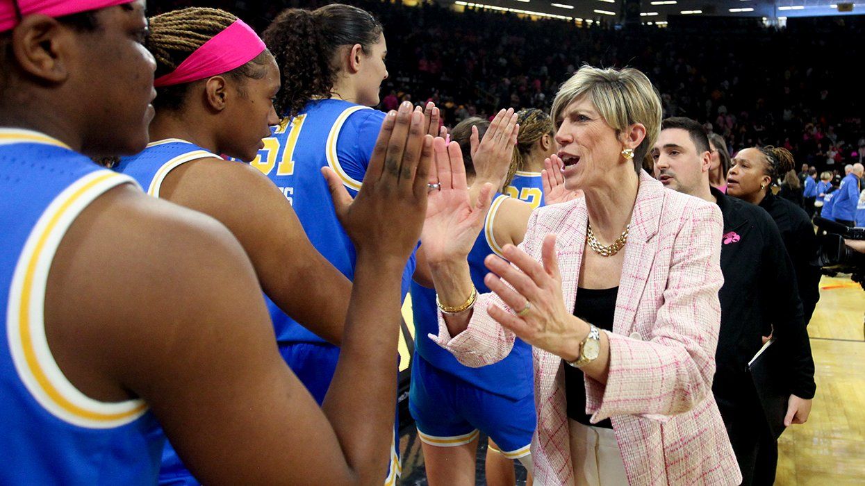 NCAA womens basketball Head coach Jan Jensen Iowa Hawkeyes in pink suit congratulates opposing players after game against UCLA Bruins
