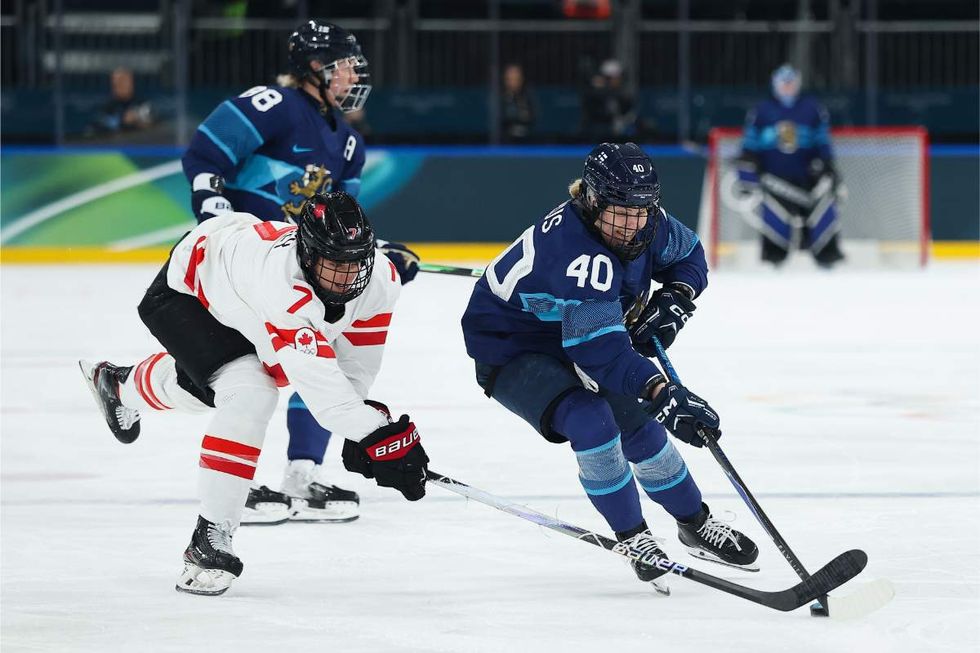 Noora Tulus #40 of Team Finland controls the puck through a stick check by Laura Stacey #7 of Team Canada