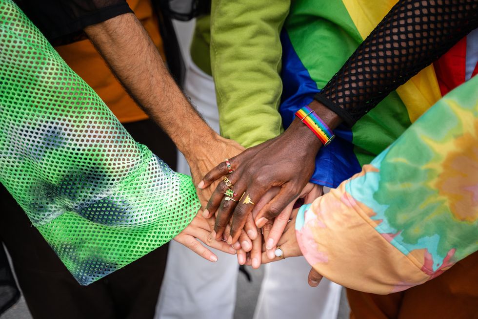 people putting their hands together in a circle