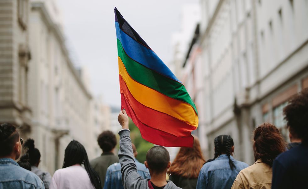 person carrying a pride flag during a march