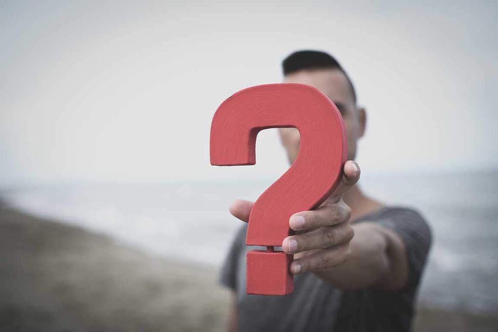 person holding a large question mark symbol