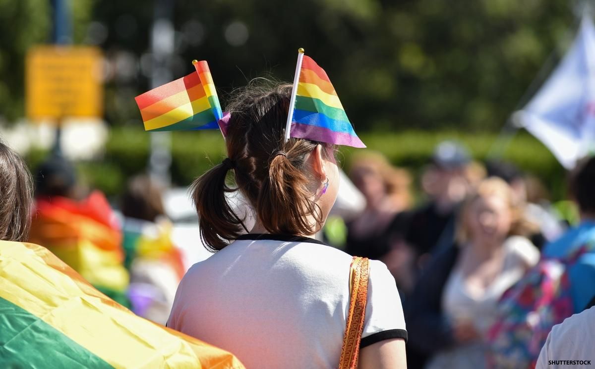 person with rainbow flags in hair