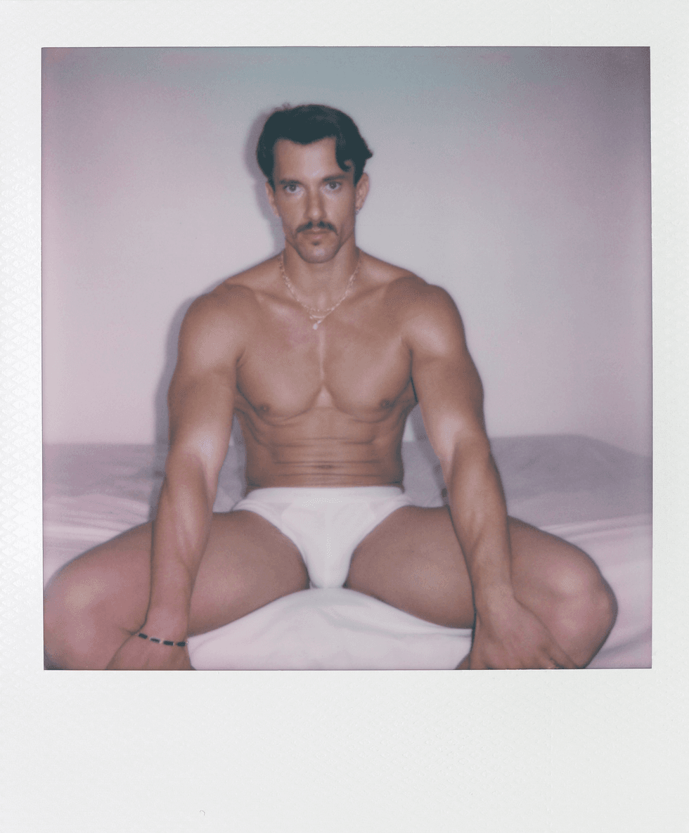 Polaroid portrait of a man sitting and looking toward the camera while wearing white briefs