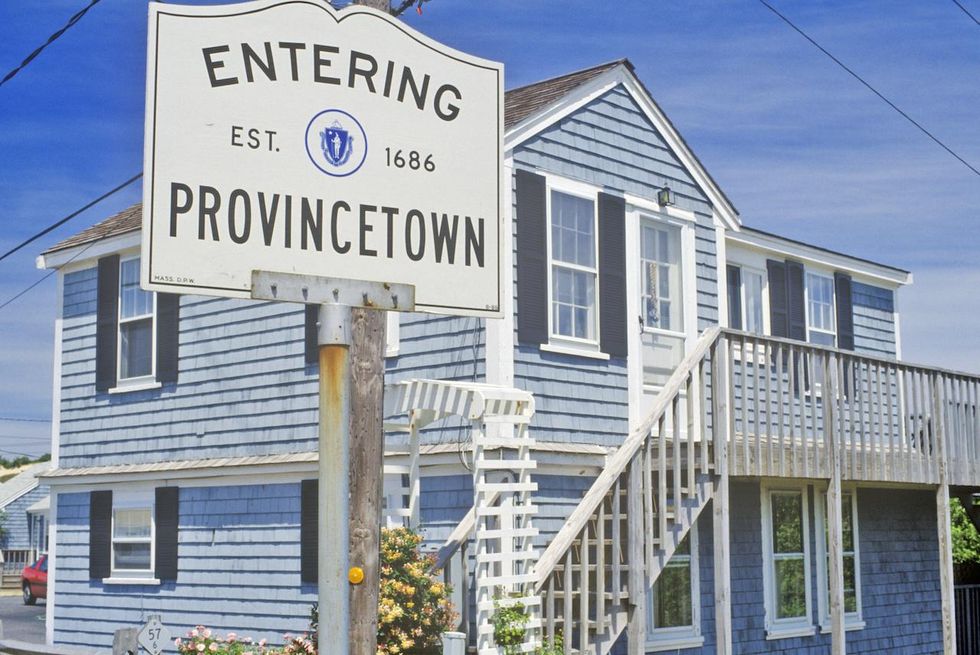 Provincetown welcome sign superimposed on a background of historical houses