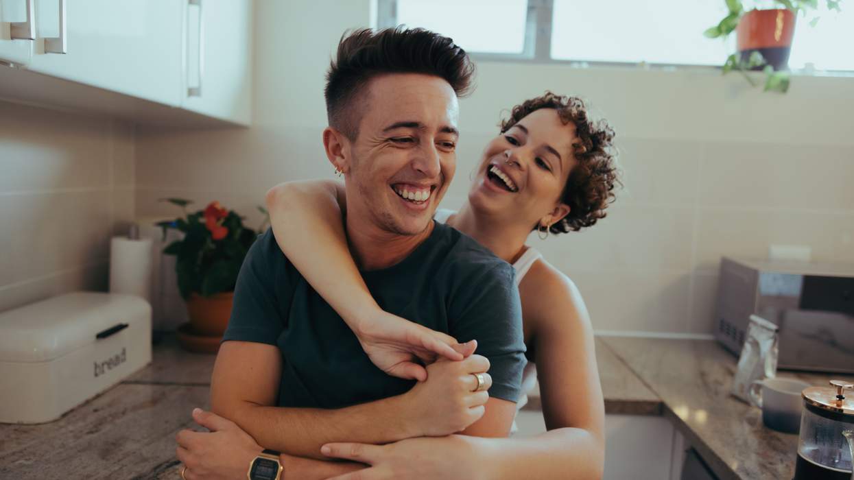 Queer Couple hugging in kitchen