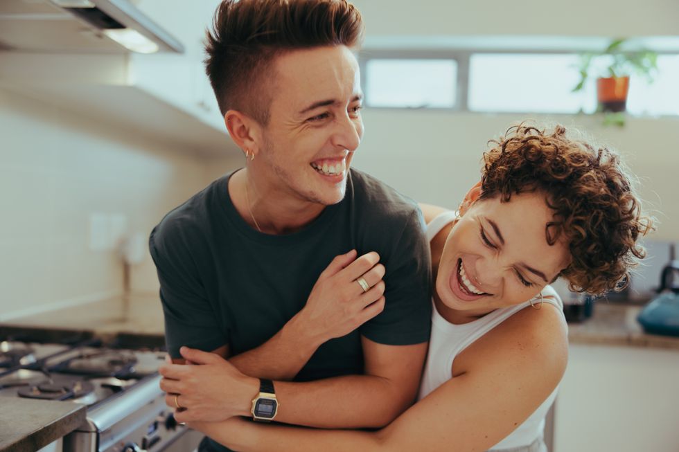 queer couple laughing in the kitchen