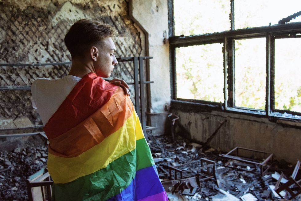 Sadness, pain and loneliness. Young attractive guy with a gay flag. Sad man.