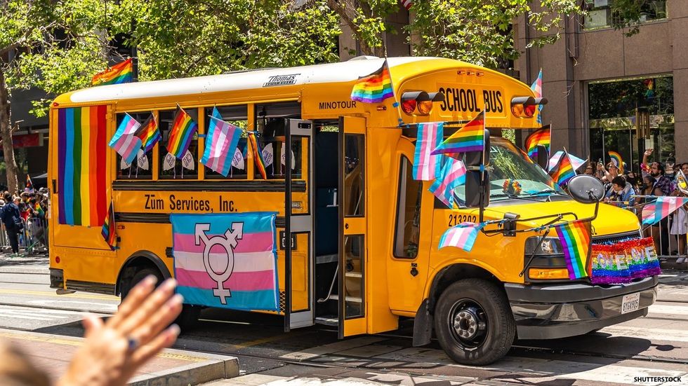 school bus with rainbow and trans flags