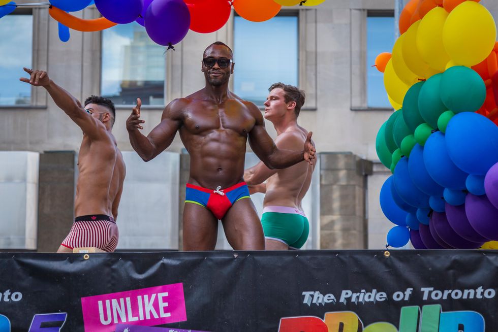 shirtless men dancing in speedos