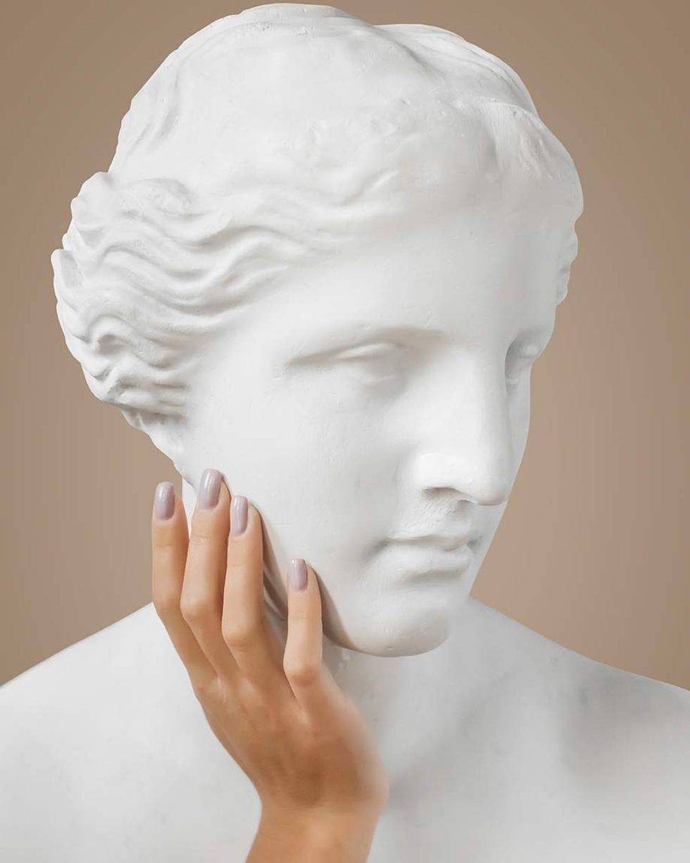 Stone bust with a human hand