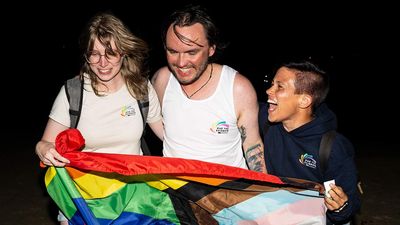 Team Oar the Rainbow OPED author pictured center holding rainbow flag