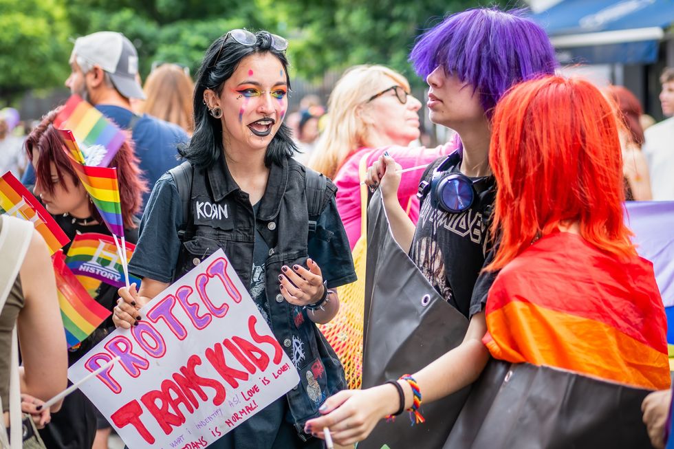 Teens holding a Protect Trans Kids sign