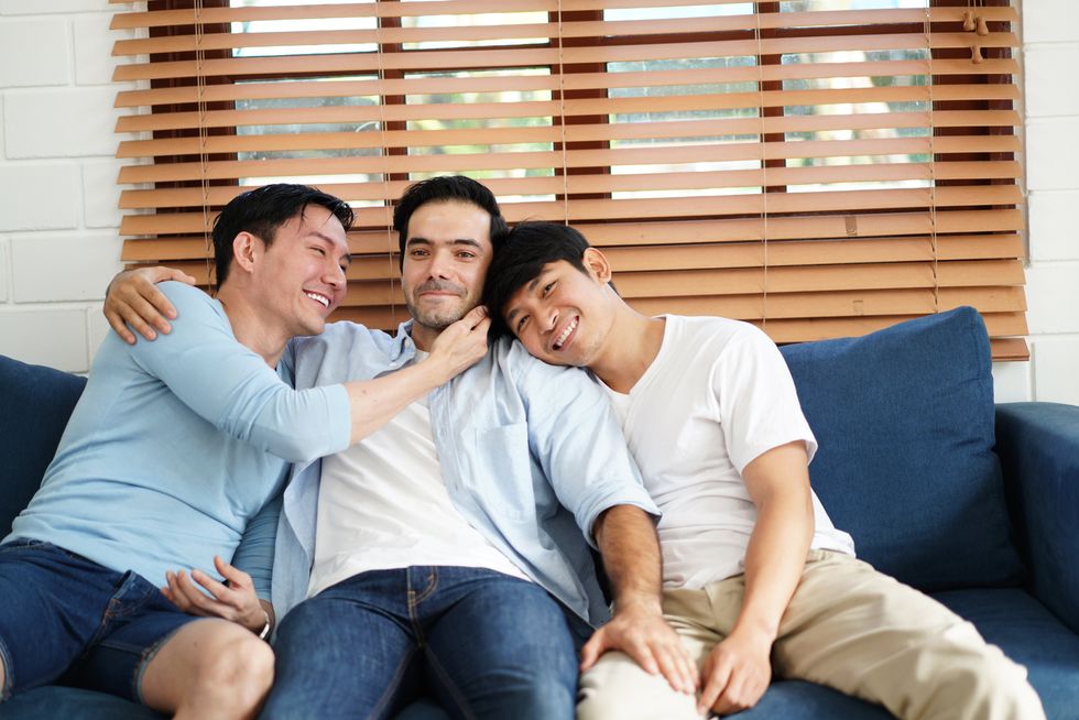 three men sitting on a couch together