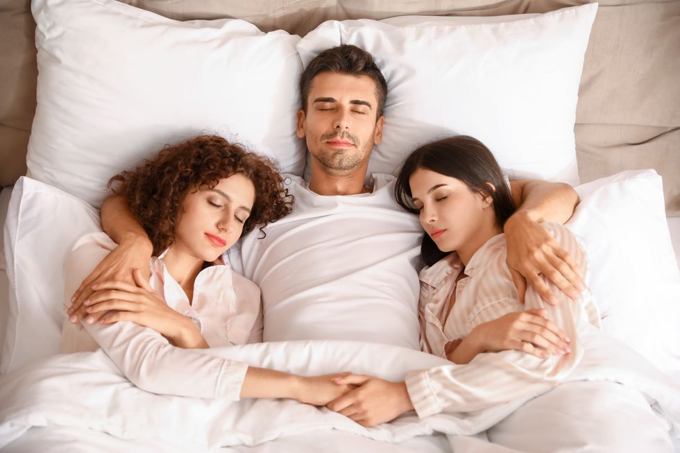 throuple in bed together