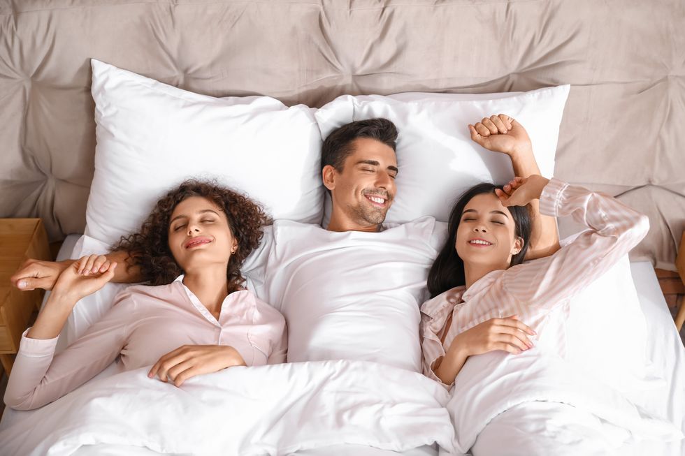 Throuple stretching in bed