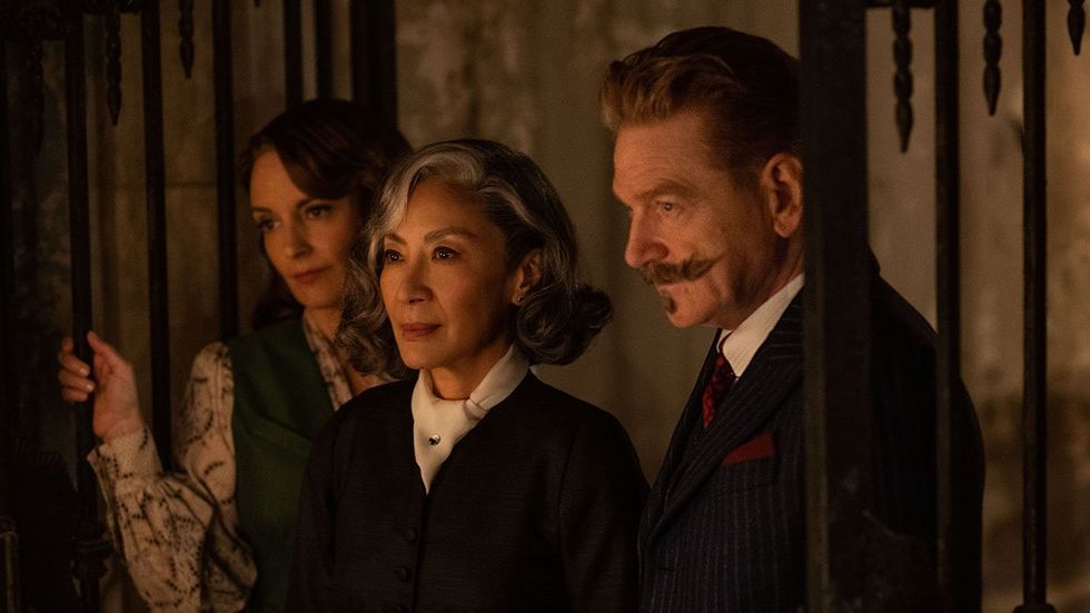 Tina Fey as Ariadne Oliver, Michelle Yeoh as Mrs. Reynolds, and Kenneth Branagh as Hercule Poirot in 20th Century Studios' A HAUNTING IN VENICE.