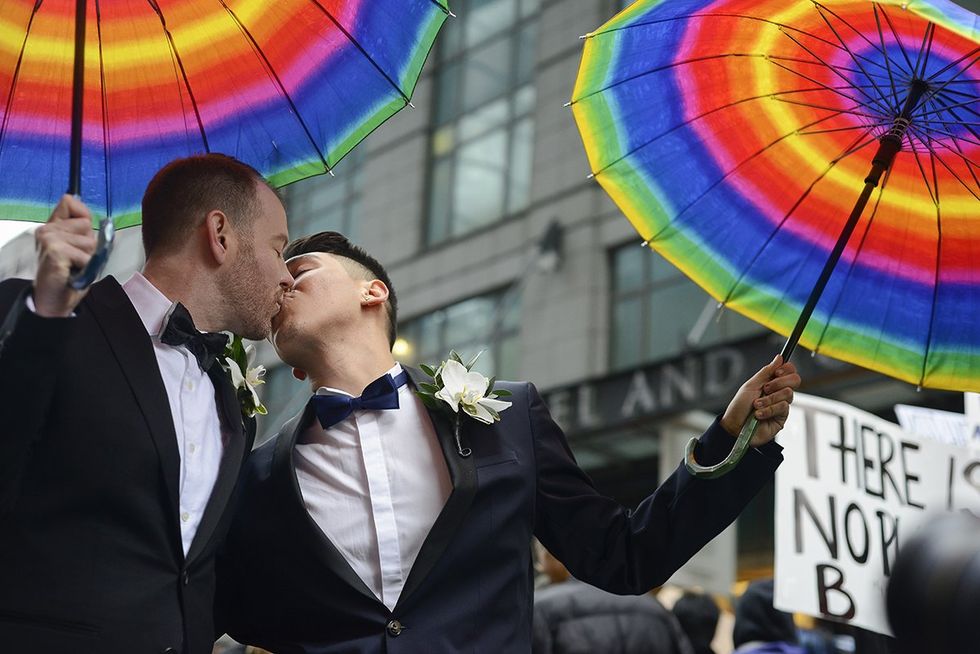 TORONTO - NOVEMBER 19: Trans couple Matthew and Miguel kissing each other during a protest in front of Trump Tower on November 19, 2016 in Toronto, Canada.