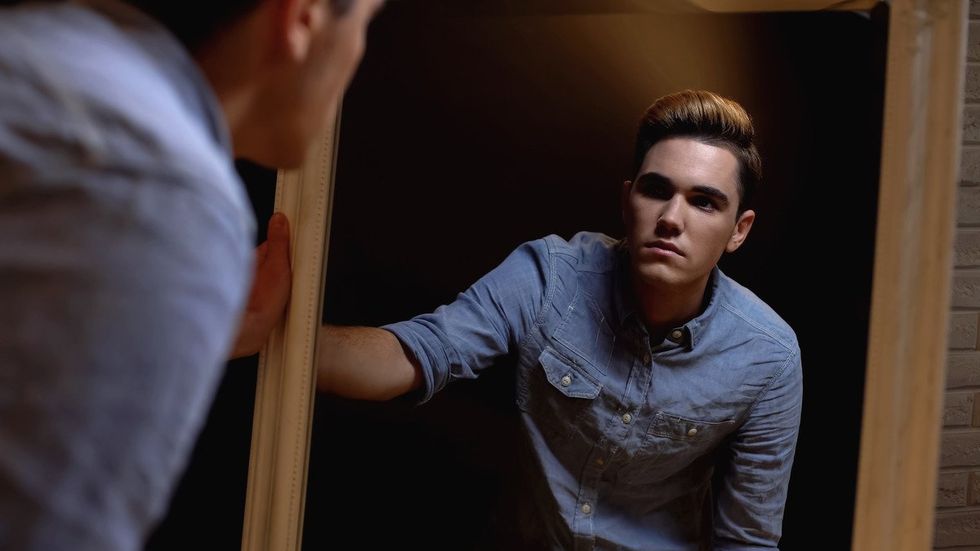 trans man looking in the mirror