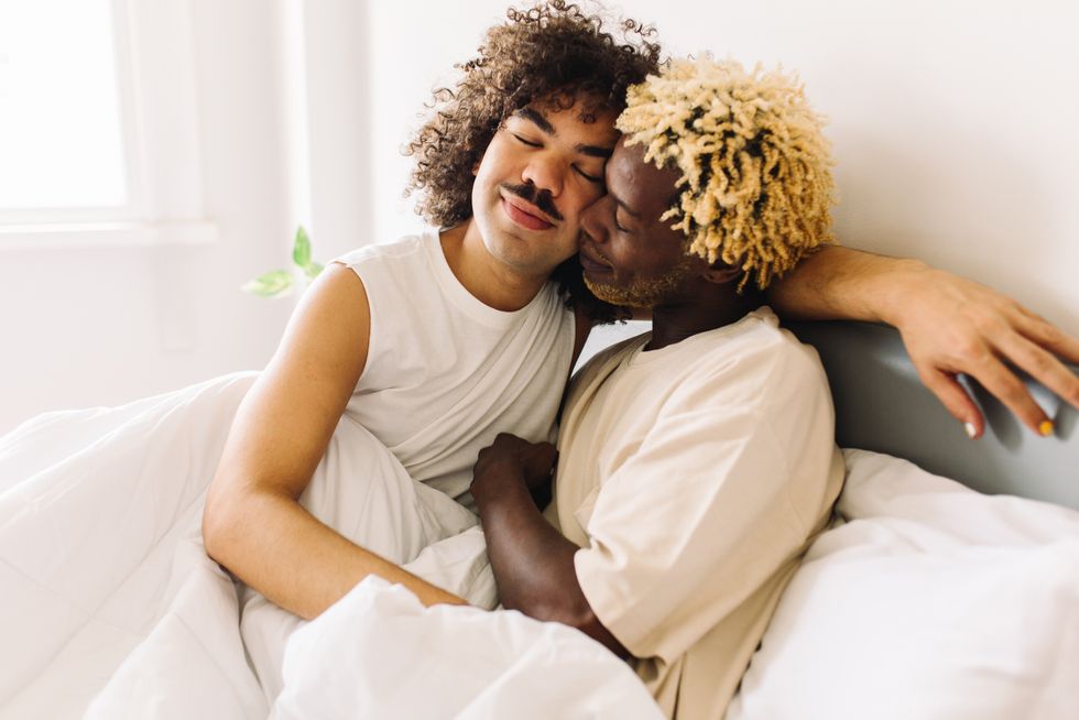 Two gay men cuddling in bed