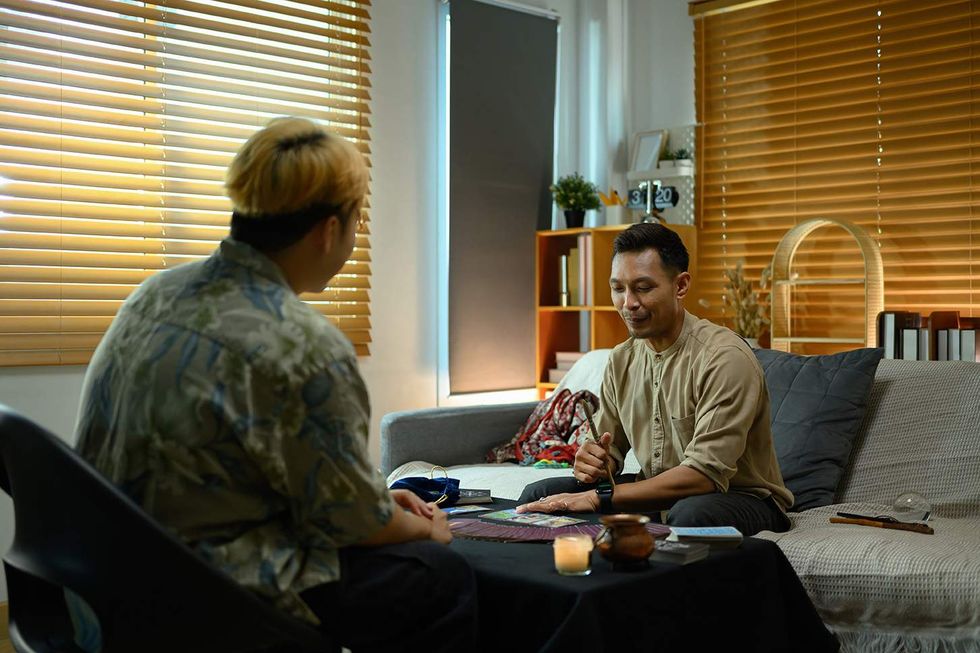Two gay men doing tarot sitting at a table