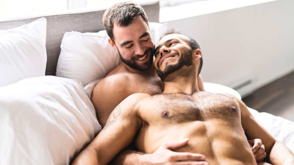 two gay men shirtless in bed