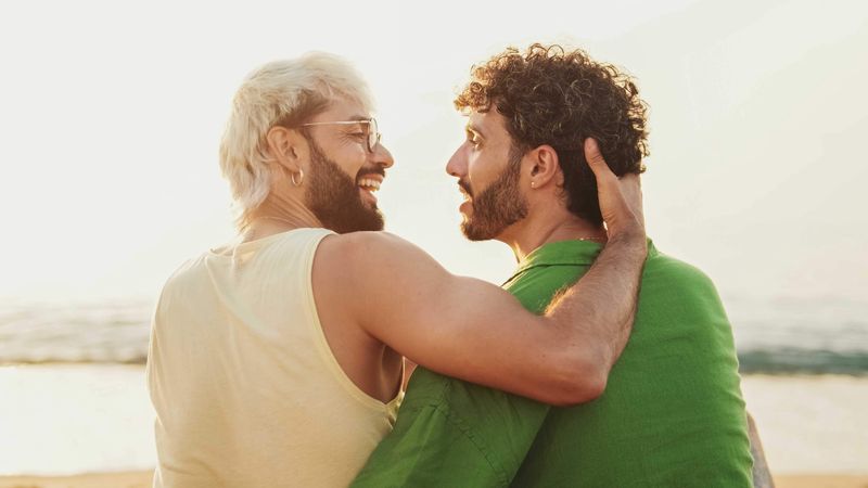 Two gay men sitting on a beach