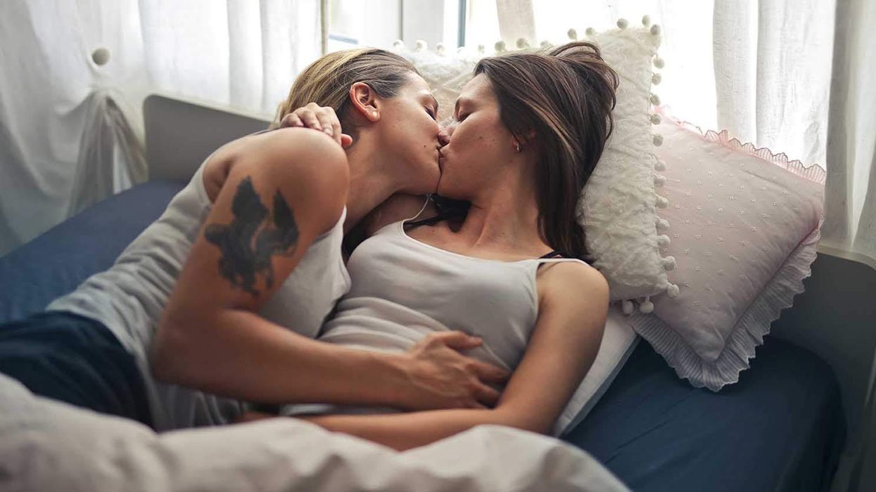 Two lesbians kissing in bed
