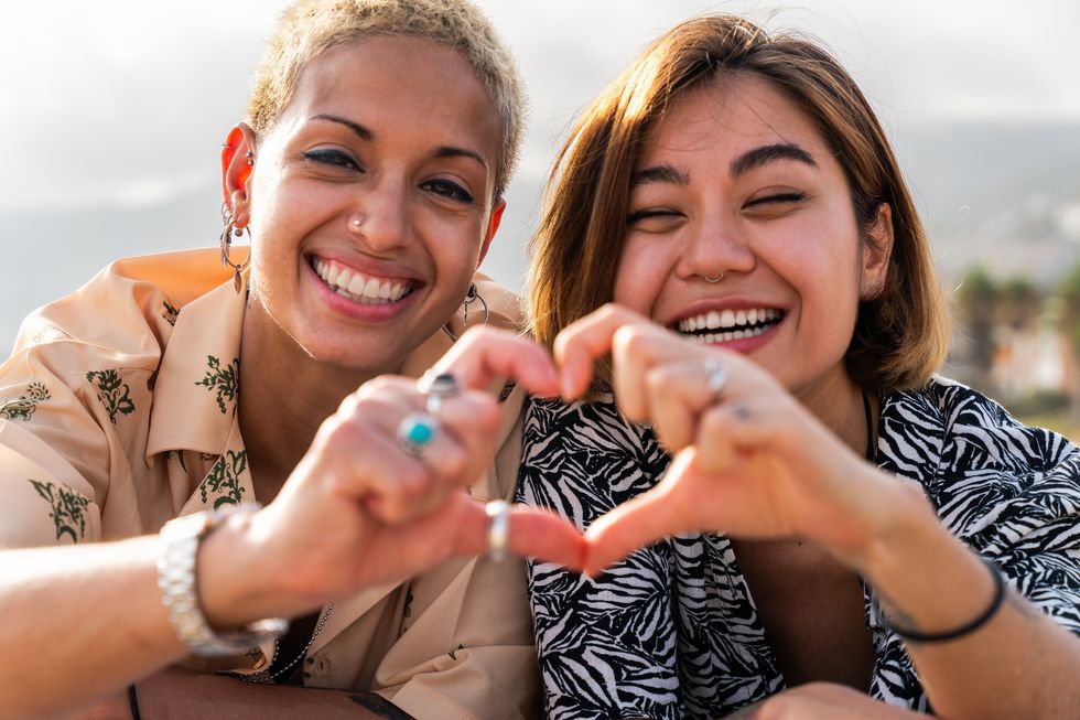 Two lesbians making a heart shape with their hands