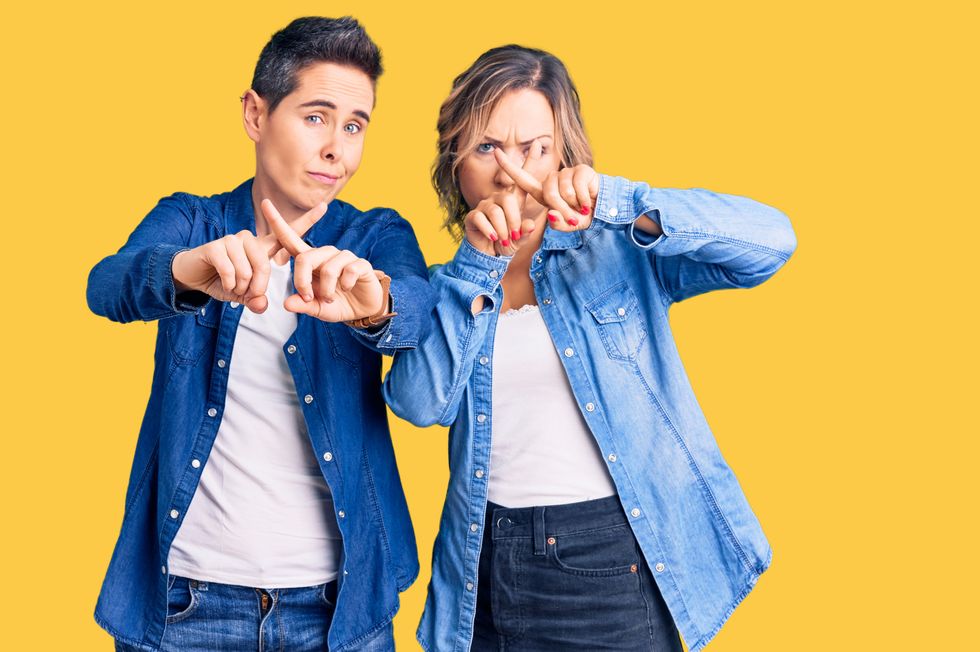 Two lesbians making Xs with their hands