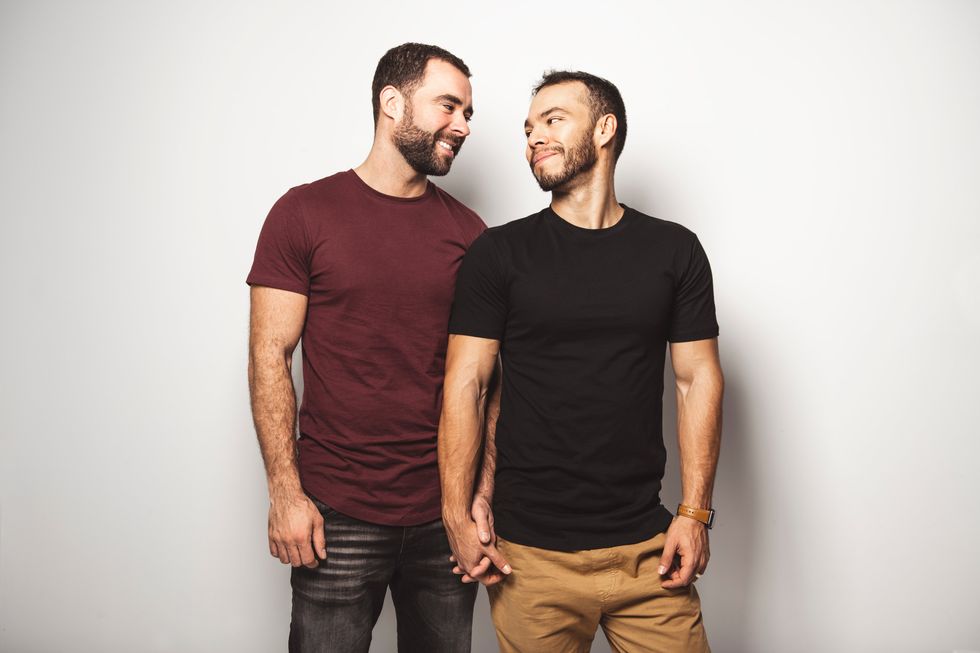 two men holding hands and gazing at each other lovingly