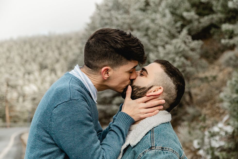 two men kissing outdoors