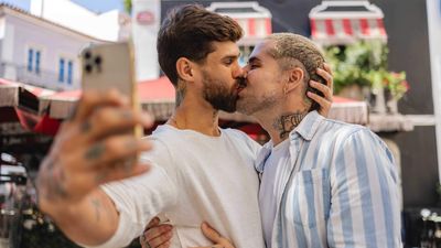 Two men kissing while taking a selfie