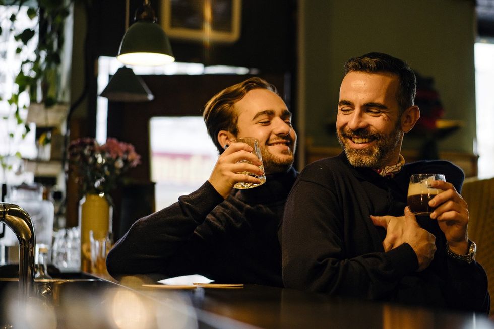 Two men laughing at warm and inviting bar