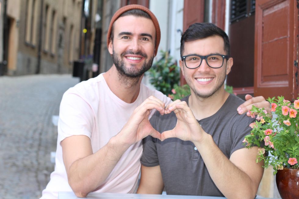 two men making a heart with their hands