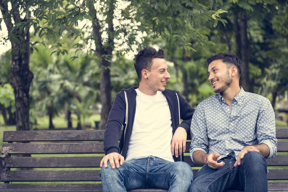 two men on a date sitting on a bench
